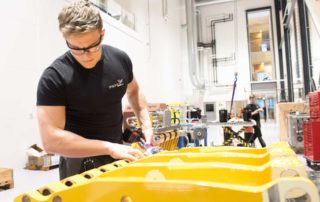 Man working with subsea pipehandler in Depro's workshop hall